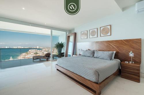 ein Schlafzimmer mit einem großen Bett und einem großen Fenster in der Unterkunft Oceanview 3 BR Penthouse with Private Terrace - BBQ in Puerto Vallarta