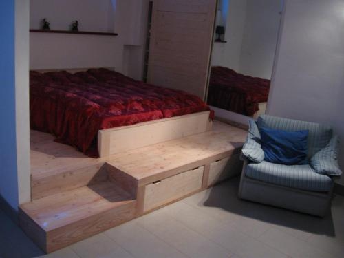 een slaapkamer met een bed met een bank en een stoel bij Loft Monte Peller in Cles