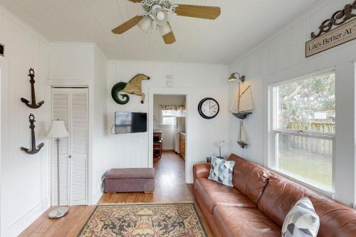 a living room with a brown leather couch and a window at Seaside Cottage in Seaside