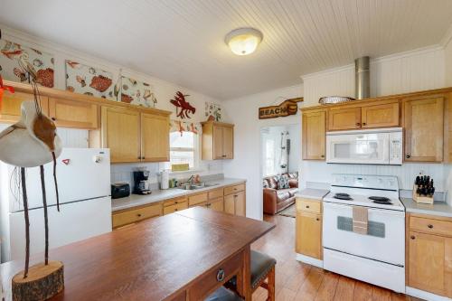 a kitchen with a table and a white refrigerator at Seaside Cottage in Seaside