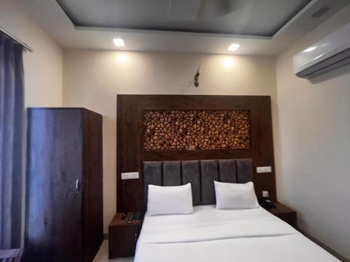 a bedroom with a bed and a wooden headboard at Sanjit Royal Stay in Mussoorie