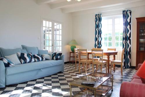 un salon avec un canapé bleu et une table dans l'établissement Maison 5 pièces 9 couchages Saint Denis d'Oléron SDO000-335, à Saint-Denis-dʼOléron