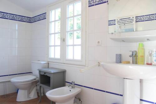 une salle de bain blanche avec des toilettes et un lavabo dans l'établissement Maison 5 pièces 9 couchages Saint Denis d'Oléron SDO000-335, à Saint-Denis-dʼOléron