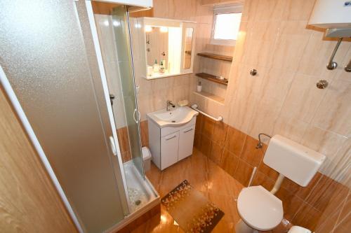 a bathroom with a toilet and a sink and a shower at lopar 239 in Lopar