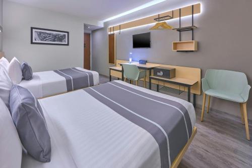 a hotel room with two beds and a desk at City Express Plus by Marriott Ciudad de México Periférico Sur Tlalpan in Mexico City