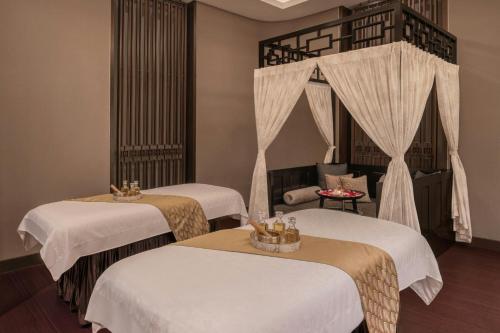 a room with two beds and a chair at The St. Regis Mumbai in Mumbai