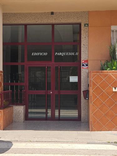 une entrée d'un bâtiment avec une porte rouge dans l'établissement Apartamento Elena, à Fuengirola
