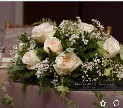 a bouquet of white roses sitting on a table at Crowne Plaza Annapolis by IHG in Annapolis