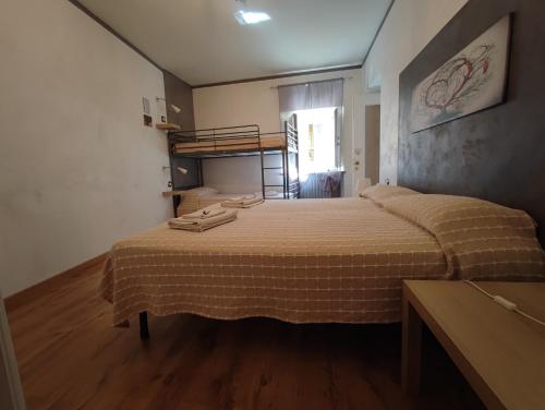 a bedroom with a bed in a room with a bunk bed at appartement de Maison Manu in Perosa Argentina