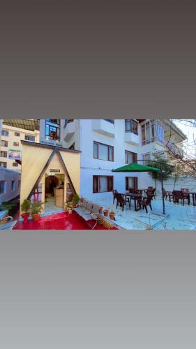 two pictures of a building with a table and umbrella at Hotel Young Mamta in Srinagar