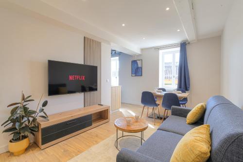 a living room with a blue couch and a tv at Wellin'Ars in Ars-sur-Formans