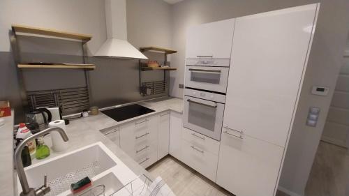 a white kitchen with a sink and a stove at Apáczai Apartment nearby Chain Bridge in Budapest