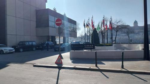 a street sign in front of a building with flags at Apáczai Apartment nearby Chain Bridge in Budapest