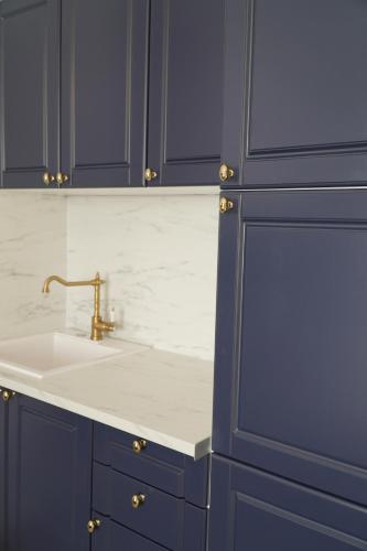 a bathroom with a sink and blue cabinets at Royal Elegance Apartment in Bucharest