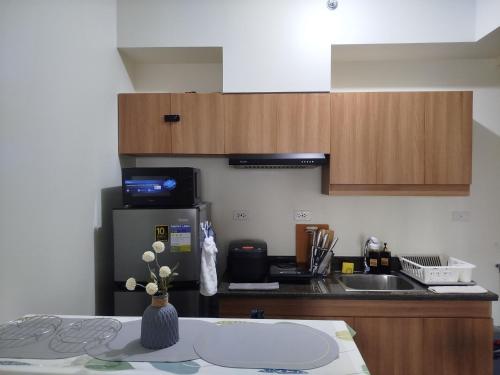 a kitchen with a counter and a refrigerator and a sink at The Orabella 27F Chill Zone with a View in Manila