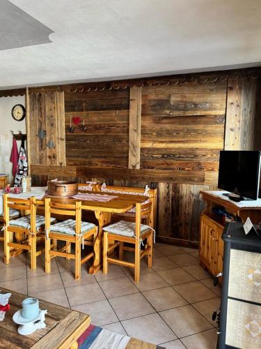 a dining room with a table and wooden walls at Fiocco di neve in Pila
