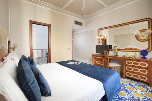 a bedroom with a bed and a vanity and a mirror at Alimuri Bay Resort in Meta