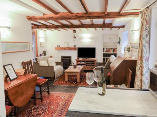 a living room with a table with a wine glass at Naunton Cottage in Lyme Regis
