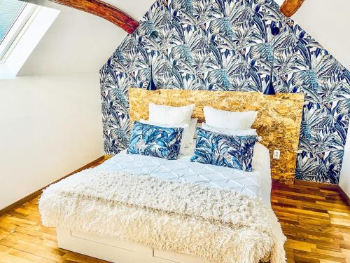 une chambre avec un lit avec des oreillers bleus et blancs dans l'établissement Luxurious century-old house with modern decor, à Dordives