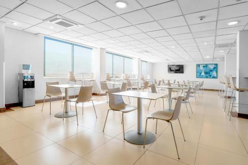 a large room with tables and chairs and windows at City Express by Marriott Aguascalientes Sur in Aguascalientes