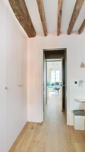 - un couloir avec des murs blancs et des plafonds en bois dans l'établissement Chic à la Parisienne, Central Paris - Marais, à Paris