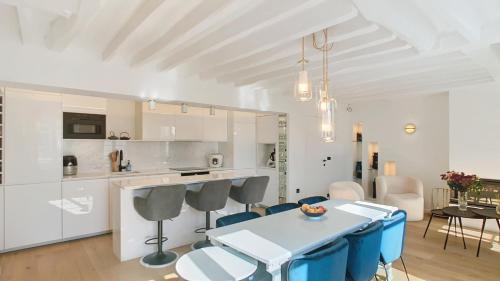 une cuisine et une salle à manger avec une table et des chaises bleues dans l'établissement Chic à la Parisienne, Central Paris - Marais, à Paris