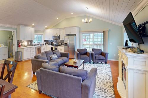 a living room with two couches and a kitchen at Seaside Comforts in Seaside