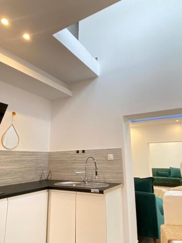 une cuisine avec un évier et un salon dans l'établissement Big, very bright house, à Beauvais