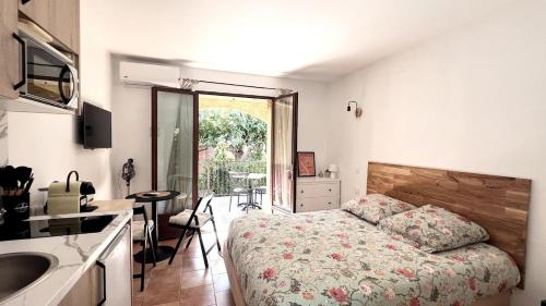 a bedroom with a bed and a kitchen with a sink at Appartement confort et équipé proche de la plage in Sisco