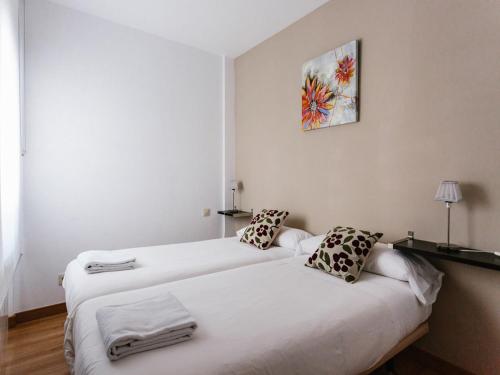 two beds in a room with white walls at Apartamentos Señorio de Haro 3000 in Haro