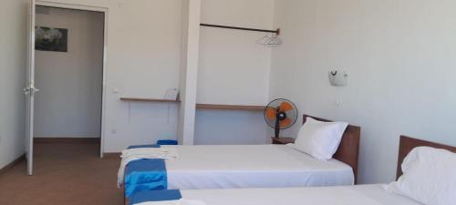 a bedroom with two beds and a mirror on the wall at Cacimba Sunset Lodge in Tarrafal