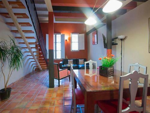 a dining room with a table and a staircase at Apartamentos Señorio de Haro 3000 in Haro
