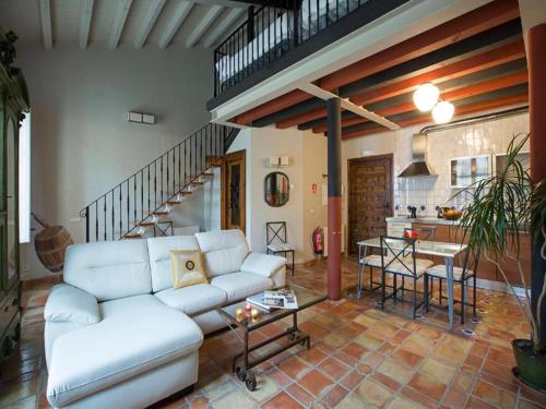 a living room with a white couch and a kitchen at Apartamentos Señorio de Haro 3000 in Haro