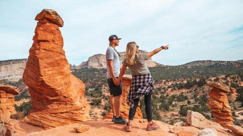 a man and woman standing on top of a rock formation at Southern Utah Hidden Gem Near Zion National Park in Orderville