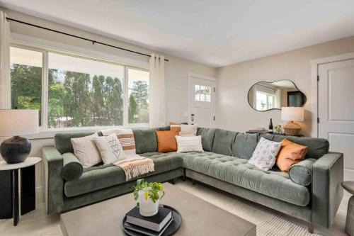 a living room with a green couch with pillows at The Holistic Hideaway in Tigard
