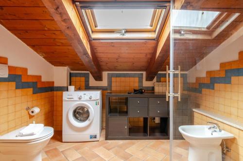 Un baño con lavadora y lavabo. en Sunflower near the center with Private Parking, en Perugia