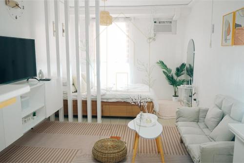 una sala de estar con un sofá y una mesa en AJV Condo Staycation, en Manila