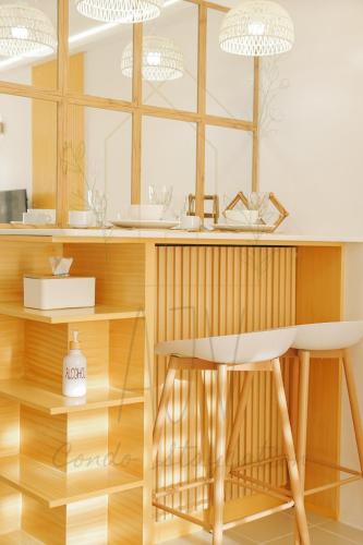 a kitchen with a counter with a stool and a table at AJV Condo Staycation in Manila
