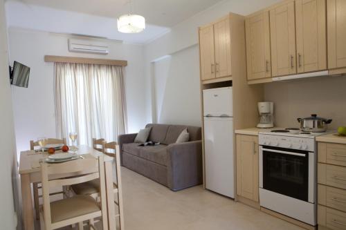 a kitchen and living room with a couch and a table at Savinos Rooms in Vasiliki