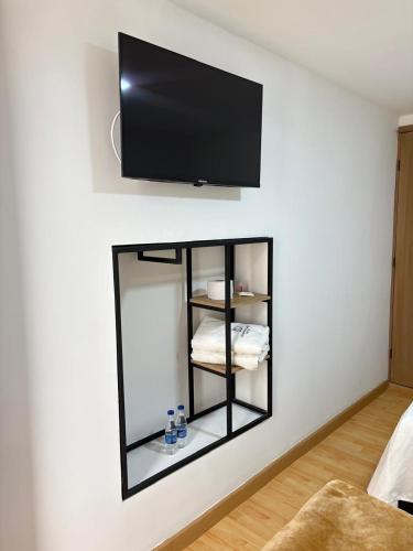 a mirror on a wall with a tv on a wall at Dadison Plaza Hotel in Piedecuesta