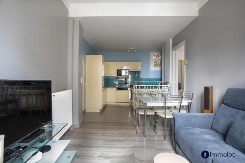 un salon avec un canapé bleu et une table dans l'établissement Apartment 10 minutes walk from Monaco, à Beausoleil