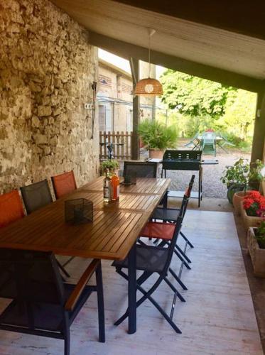 une table et des chaises en bois sur une terrasse dans l'établissement Havre de paix en Lot-et-Garonne, à Lédat