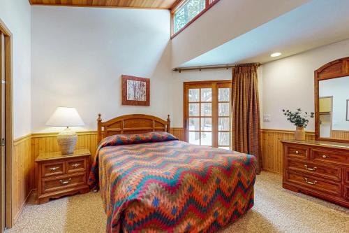 een slaapkamer met een bed, een ladekast en een spiegel bij 1 Raccoon Lane in Sunriver