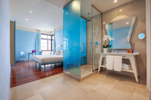 a bathroom with a glass shower and a bedroom at JR Hotels Bari Grande Albergo delle Nazioni in Bari