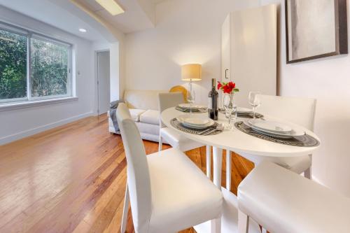 a white dining room with a white table and chairs at Mbird Estoril Riviera Flat 1 in Estoril