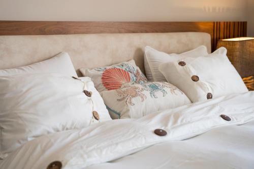 a bedroom with white pillows and a bed at Mangroovy Seafront condo - Great Kite Surfing in Hurghada