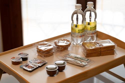 a table with two bottles of water and some treats at 10min Auto Udine Centro Garage coperto Free Wifi in Godia