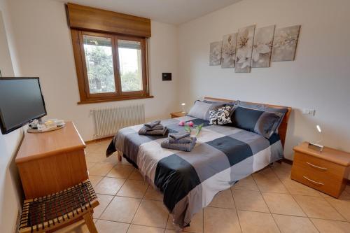 a bedroom with a large bed and a television at 10min Auto Udine Centro Garage coperto Free Wifi in Godia