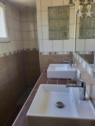 une salle de bain avec un lavabo blanc et un miroir dans l'établissement Maisonnette près du centre ville, à Saint-Maximin-la-Sainte-Baume