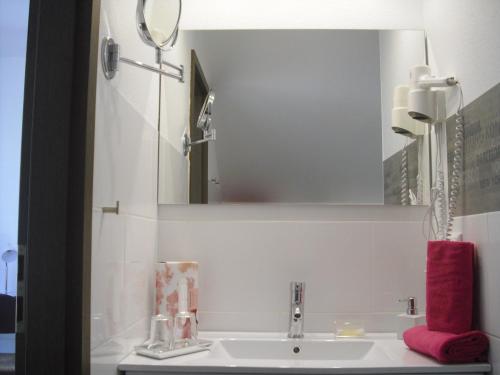 a bathroom sink with a mirror and a red towel at Gästehaus Cramer in Bad Kissingen